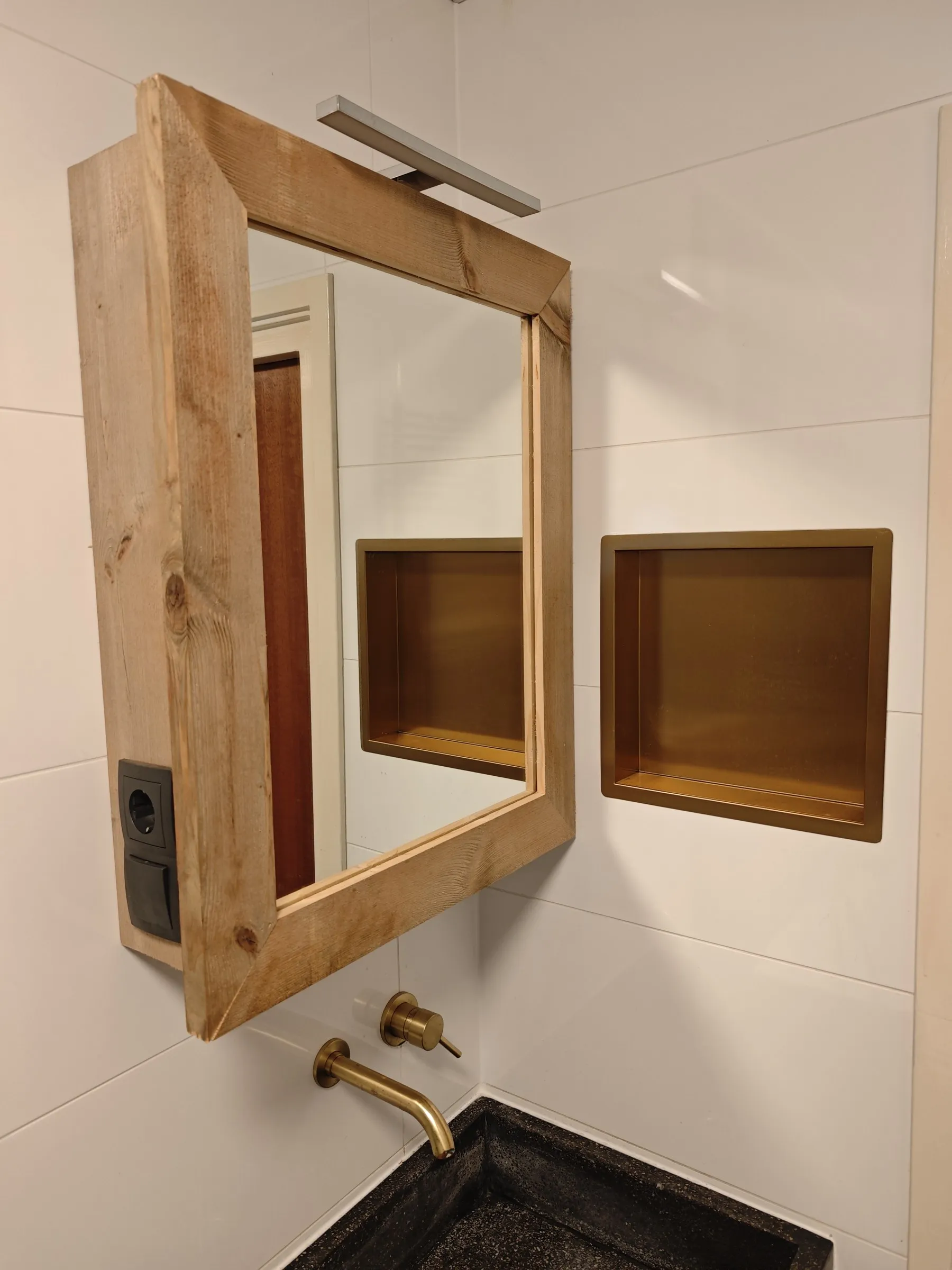 Spiegel met houten lijst en een nis in de wand