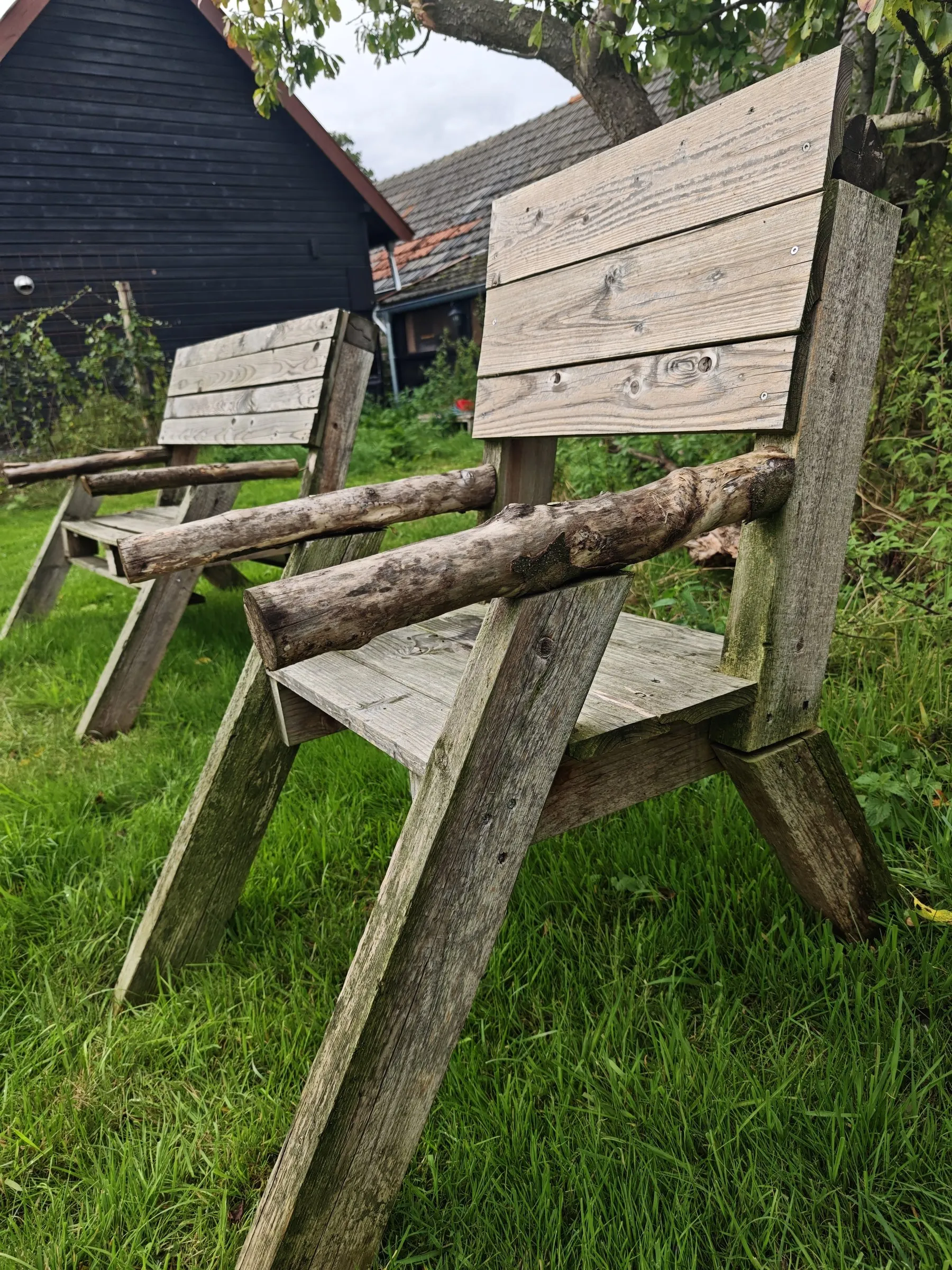 Twee houten tuinstoelen in het gras