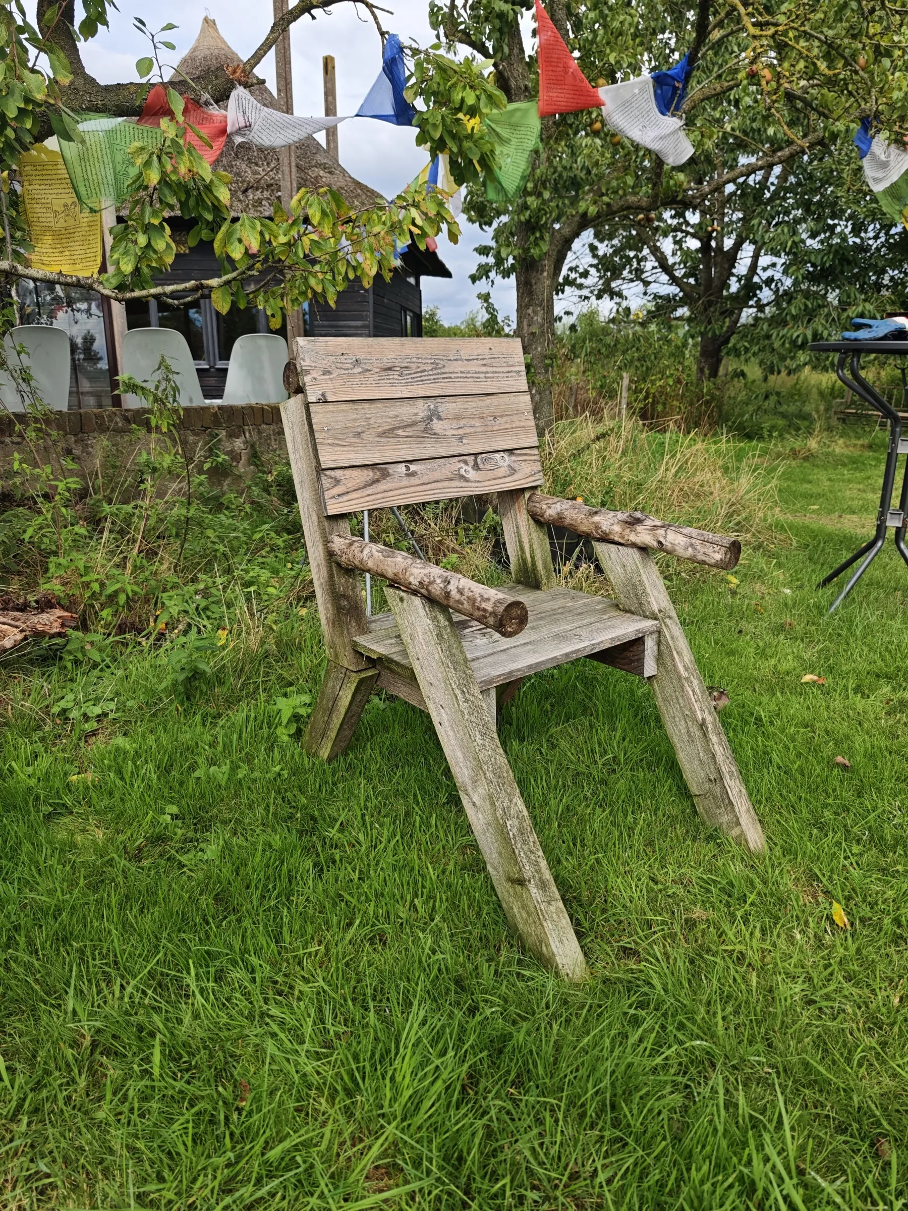 Tuinstoel in het gras onder de bomen
